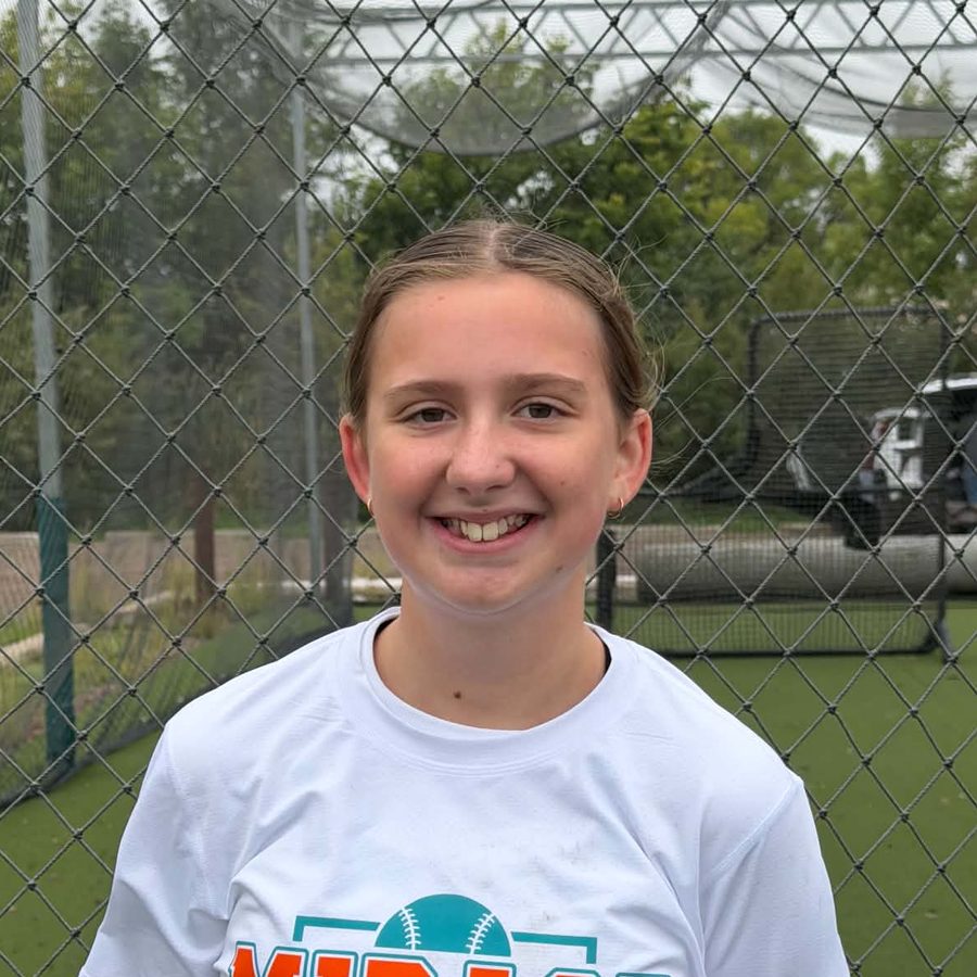 Evie S. in a Mirage Softball shirt at the batting cages