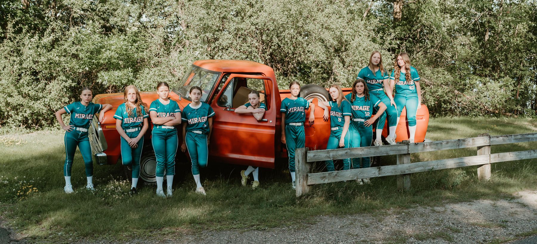The Minnesota Mirage team in teal uniforms alongside an orange pickup truck